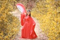 Young beautiful asian woman dress in traditional Chinese old fashion warrior style with ancient fan. Cute girl in red dress standi Royalty Free Stock Photo