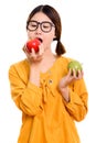 Young beautiful Asian woman eating red apple while holding green Royalty Free Stock Photo