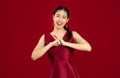 Young beautiful asian woman in elegant red dress posing greeting and respect on red color background. Happy Chinese New Year Royalty Free Stock Photo