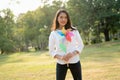 Young Beautiful Asian Woman holding the colorful windmill toward the camera with big happy smile feeling carefree and happy with Royalty Free Stock Photo
