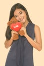 Young beautiful Asian woman holding teddy bear with heart and love sign Royalty Free Stock Photo