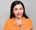 Young beautiful asian woman,long black hair, wore orange t shirt, Pointing finger forward, Show a question remind face,Don`t