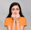 Young beautiful asian woman,long black hair, wore orange t shirt, Show a appeal face,request, on gray background