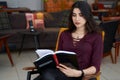 Young beautiful Asian woman reading book in a cafe Royalty Free Stock Photo