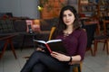 Young beautiful Asian woman reading book in a cafe Royalty Free Stock Photo