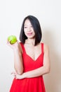 Young beautiful asian woman red dress looking green apple Royalty Free Stock Photo