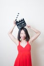 Young beautiful asian woman red dress smiling with clapperboard Royalty Free Stock Photo
