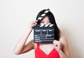 Young beautiful asian woman red dress smiling eyes with clapperboard Royalty Free Stock Photo