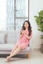 Young beautiful asian woman relaxing in sofa with cup of pure wa Royalty Free Stock Photo