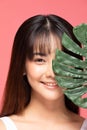 Young Beautiful Asian woman smile with clean and fresh skin with green leaf cover on face