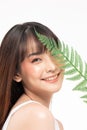 Young Beautiful Asian woman smile with clean and fresh skin with green leaf cover on face