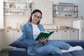 Young beautiful asian woman studying at home, happy female student smiling reading book Royalty Free Stock Photo