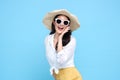 Young beautiful Asian woman in summer casual clothes wearing straw hat, sunglasses say something and hand side mouth and smile on