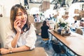 Young and beautiful Asian woman talking on mobile phone at coffee shop, communication or cafe casual lifestyle concept