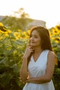 Young beautiful Asian woman thinking in the field of blooming su Royalty Free Stock Photo