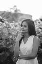 Young beautiful Asian woman thinking in the field of blooming sunflowers Royalty Free Stock Photo