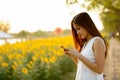 Young beautiful Asian woman using mobile phone against field of Royalty Free Stock Photo