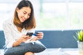 Young beautiful Asian woman using smartphone and credit card for online shopping at home with copy space. E-payment technology Royalty Free Stock Photo