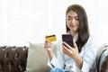 Young beautiful Asian woman using smartphone and credit card for online shopping at home with copy space Royalty Free Stock Photo