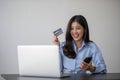 Young beautiful Asian woman using smartphone and credit card for online shopping at home with copy space. E-payment Royalty Free Stock Photo