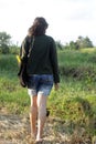 Young beautiful woman walking from behind on field carry, sunflower on bag. Royalty Free Stock Photo