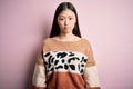 Young beautiful asian woman wearing animal print fashion sweater over pink isolated background depressed and worry for distress,