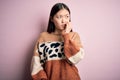 Young beautiful asian woman wearing animal print fashion sweater over pink isolated background looking stressed and nervous with