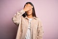 Young beautiful asian woman wearing casual shirt standing over pink background covering eyes with hand, looking serious and sad Royalty Free Stock Photo