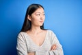 Young beautiful asian woman wearing casual sweater standing over blue  background looking to the side with arms crossed Royalty Free Stock Photo