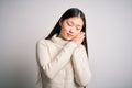 Young beautiful asian woman wearing casual sweater standing over isolated background sleeping tired dreaming and posing with hands