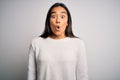 Young beautiful asian woman wearing casual sweater standing over white background afraid and shocked with surprise expression, Royalty Free Stock Photo