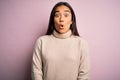 Young beautiful asian woman wearing casual turtleneck sweater over pink background afraid and shocked with surprise expression, Royalty Free Stock Photo