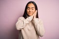 Young beautiful asian woman wearing casual turtleneck sweater over pink background sleeping tired dreaming and posing with hands Royalty Free Stock Photo
