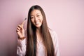 Young beautiful asian woman wearing pajama brushing her teeth using tooth brush and oral paste, cleaning teeth and tongue as Royalty Free Stock Photo