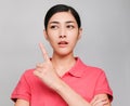 Young beautiful asian woman wore pink t shirt, Showed Pointing and thinking expression , on gray background Royalty Free Stock Photo