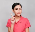 Young beautiful asian woman wore pink t shirt, Showed Pointing and wondering expression , on gray background