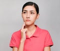 Young beautiful asian woman wore pink t shirt, Showed Thinking and serious expression , on gray background Royalty Free Stock Photo