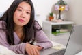 Young beautiful Asian woman working with laptop on bed -  lifestyle home portrait of young pretty and happy Japanese student girl Royalty Free Stock Photo