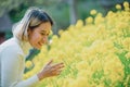 Young beautiful Asian women gardener take care of her flower in backyard. Yellow flower outdoor