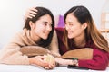 Young beautiful Asian women lesbian couple lover giving gift box in bed room at home with smiling face.Concept of LGBT sexuality