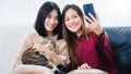 Young beautiful Asian women lesbian couple lover using smartphone selfie cute cat pet in living room at home with smiling face.