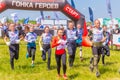 Young beautiful athletic people starts on a traditional race of heroes. Text in Russian: Start, race of heroes, throw Royalty Free Stock Photo