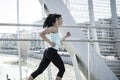 Young beautiful athletic sport woman running and jogging crossing modern metal city bridge Royalty Free Stock Photo