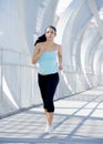 Young beautiful athletic sport woman running and jogging crossing modern metal city bridge Royalty Free Stock Photo