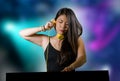 Young beautiful and attractive Asian Chinese DJ woman remixing music at night club wearing headphones isolated on flashes and Royalty Free Stock Photo