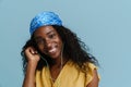 Young beautiful attractive long-haired curly smiling african woman touching headphones Royalty Free Stock Photo