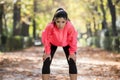 Attractive sport woman in runner sportswear breathing gasping and taking a break tired and exhausted after running workout on Autu