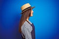 Young beautiful baker woman wearing apron and hat standing over isolated blue background looking to side, relax profile pose with Royalty Free Stock Photo