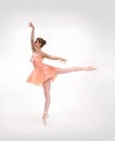 A young ballet dancer in an orange dress