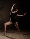 Young beautiful ballet dancer in pointe shoes, dancing in a dark background